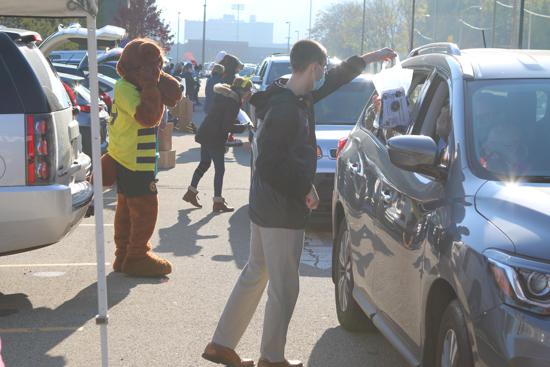 Picture of Pittsburgh Riverhounds mascot, AMO, and two other Hounds employees giving away candy at the Frightfully Fun Drive Thru Trick Or Treating 