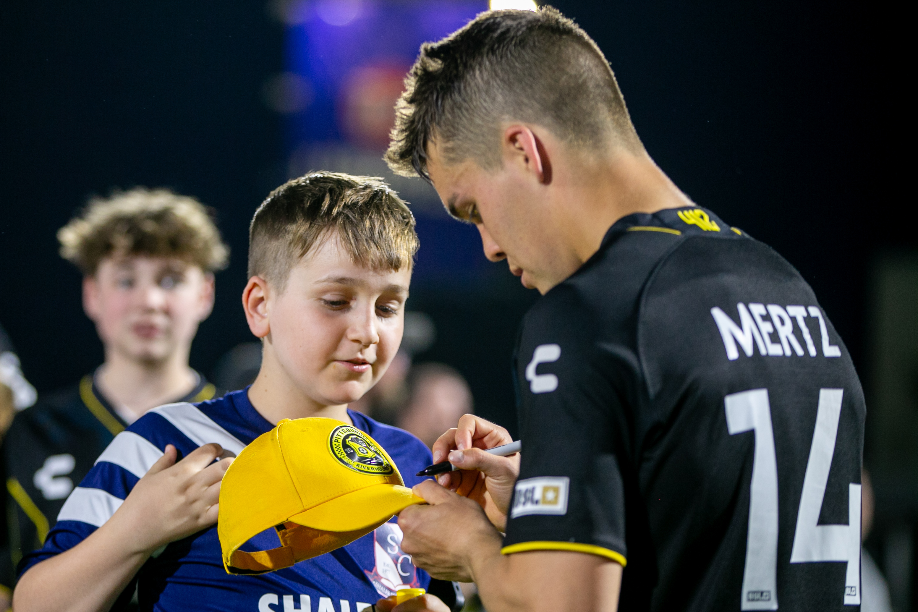 Robbie Mertz autographs a hat for a fan.