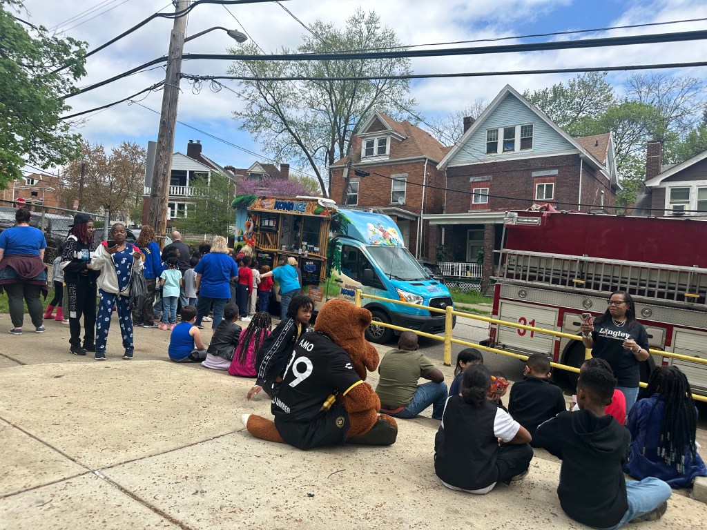 Picture of Pittsburgh Riverhounds mascot AMO at a community event with a bunch of kids. 