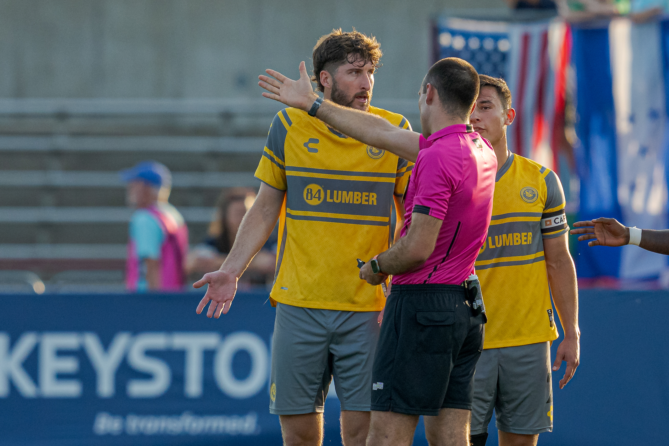 Hounds players Pat Hogan and Danny Griffin protest as referee Elijio Arreguin points toward the locker room after changing his decision to a red card sending off Pat Hogan in the fourth minute of the Hounds' 1-1 draw with Indy Eleven on Aug. 31, 2024 at Michael A. Carroll Stadium in Indianapolis. (Photo: Matt Schlotzhauer/Indy Eleven)