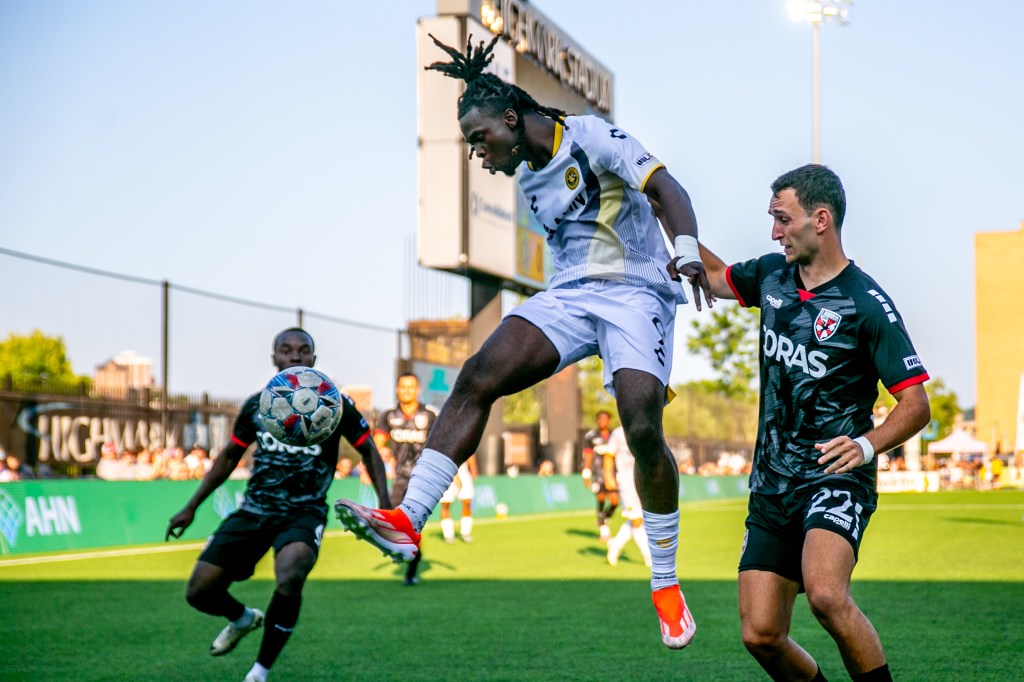 The Riverhounds' Emmanuel Johnson leaps to control the ball in front of Loudoun United FC defender Robby Dambrot in the teams' 1-1 draw July 27, 2024, at Highmark Stadium. (Photo: Chris Cowger/Riverhounds SC)