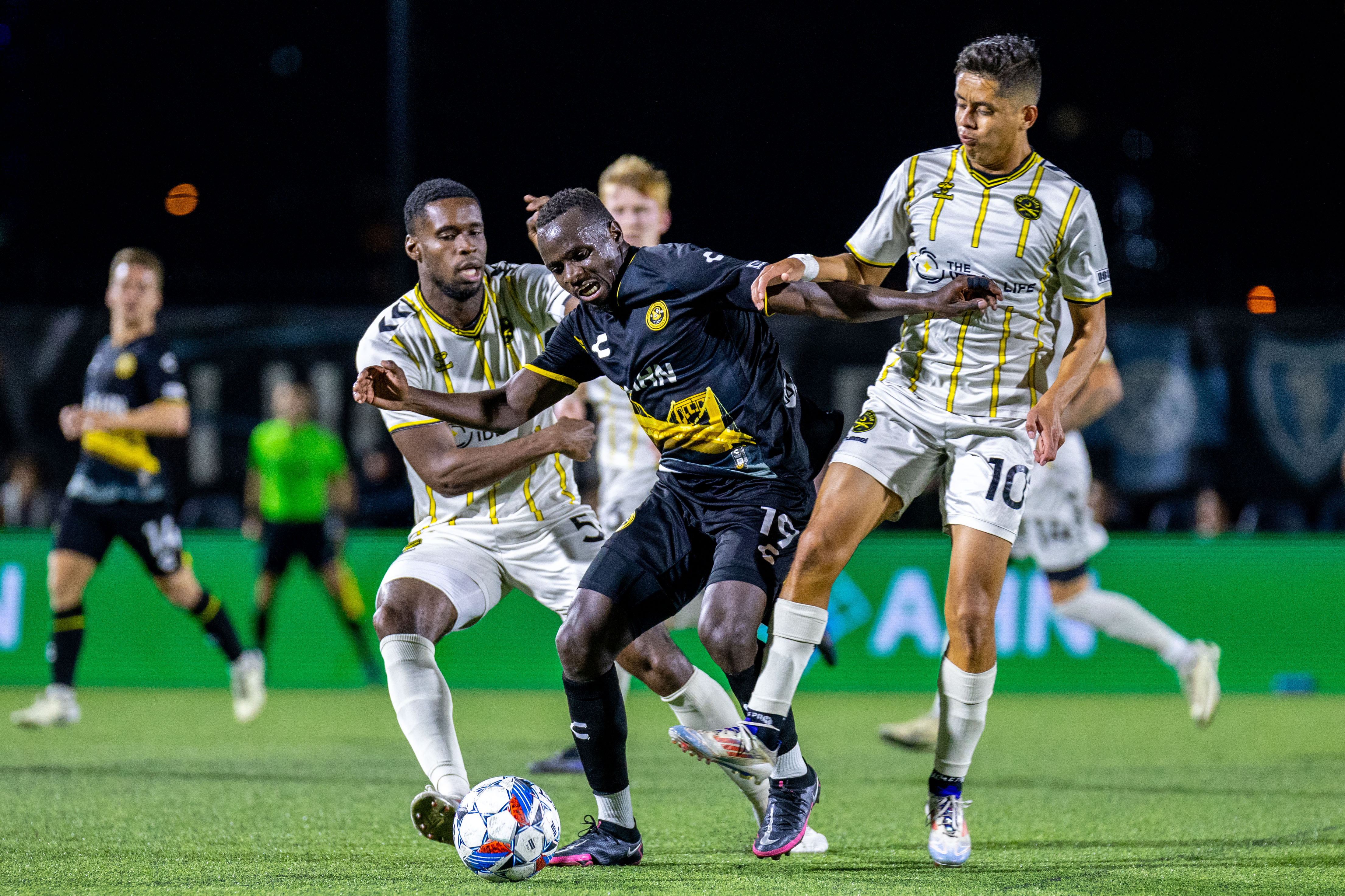 Hounds forward Edward Kizza squeezes between the Charleston Battery's Leland Archer (left) and Arturo Rodriguez in the Hounds' 2-0 win Oct. 12, 2024, at Highmark Stadium in Pittsburgh. (Photo: Chris Cowger/Riverhounds SC)