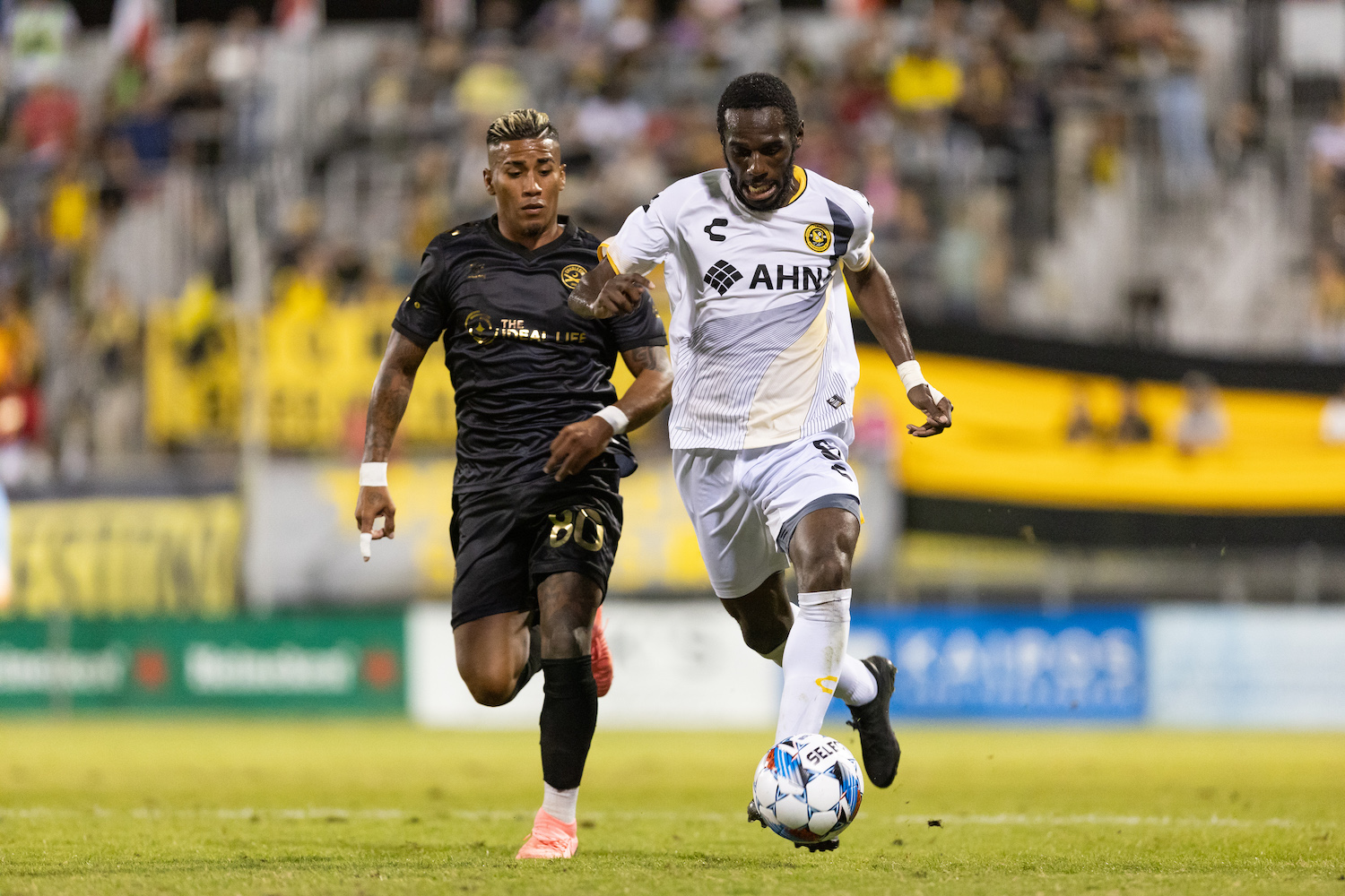 Riverhounds wing back Junior Etou dribbles past Charleston Battery midfielder Juan Torres in the Hounds' 1-0 loss in the USL Championship Playoffs on Nov. 2, 2024 at Patriots Point Soccer Complex in Mount Pleasant, S.C. (Photo: Mallory Neil/Riverhounds SC)