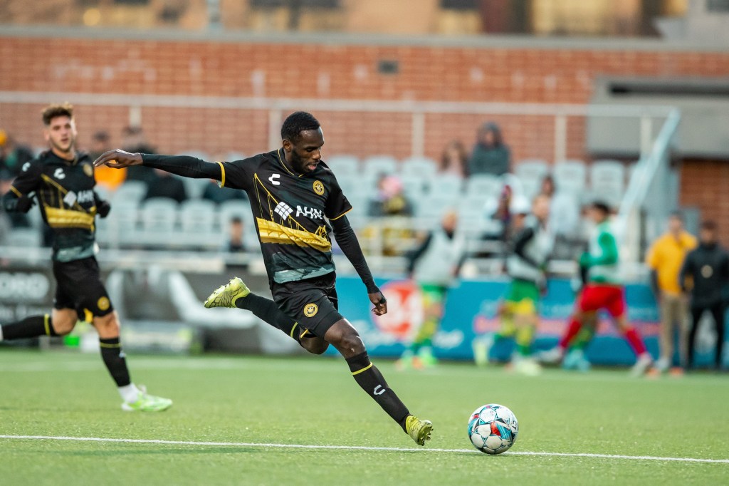 Pittsburgh Riverhounds wing back Junior Etou plays a long pass in the team's 0-0 draw with the Tampa Bay Rowdies on April 6, 2024, at Highmark Stadium. (Photo: Mallory Neil/Riverhounds SC)